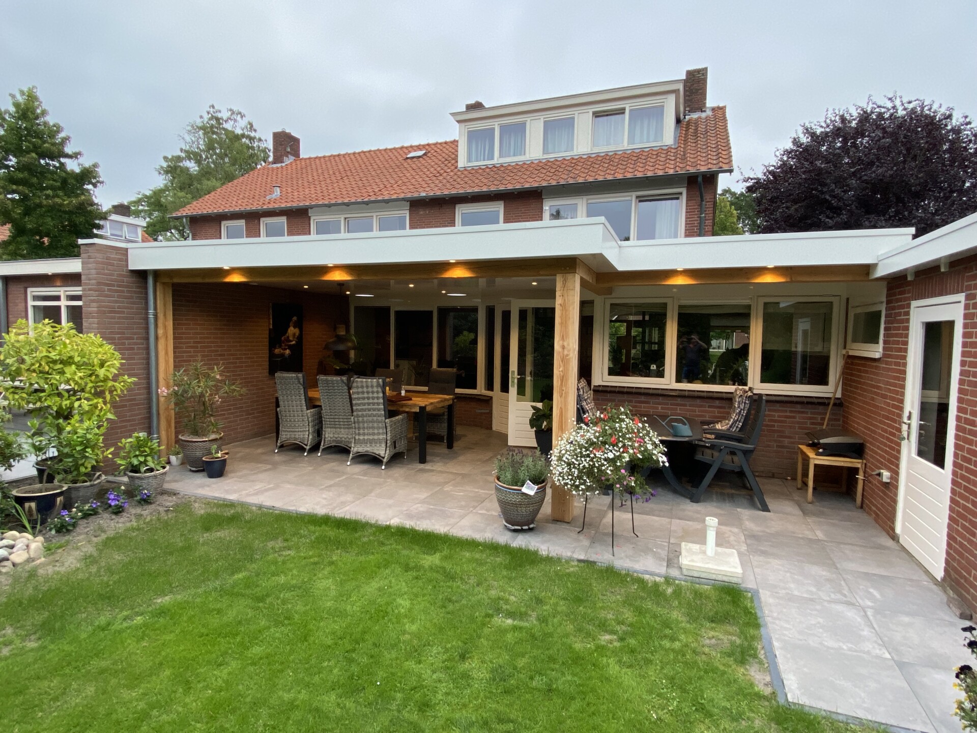 Moderne overkapping in Delden met eiken accenten en solartubes voor extra daglicht onder de overkapping.