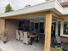 Moderne overkapping in Delden met eiken accenten en solartubes voor extra daglicht onder de overkapping.